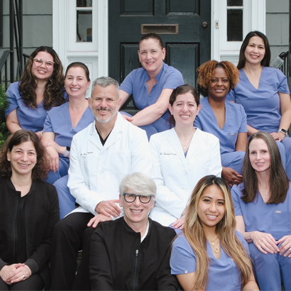 Ferguson Dental team members posing together outside a dental office entrance.