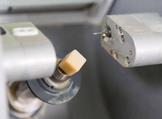 Dental handpiece turbine rotor with gold ceramic bearing in dental equipment closeup.